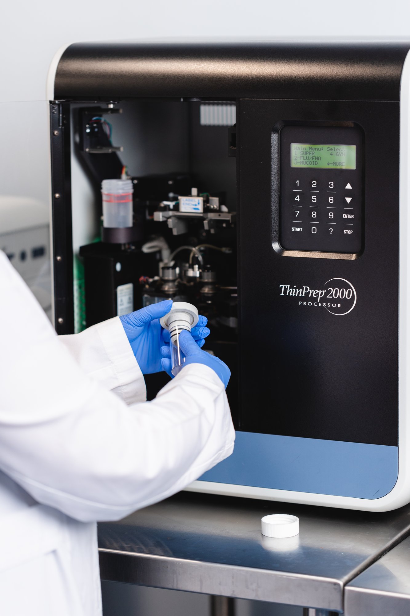 Científico manipulando muestra en máquina ThinPrep 2000 en laboratorio clínico