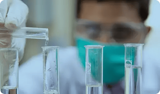 Científico en laboratorio usando tubos de ensayo con líquidos transparentes