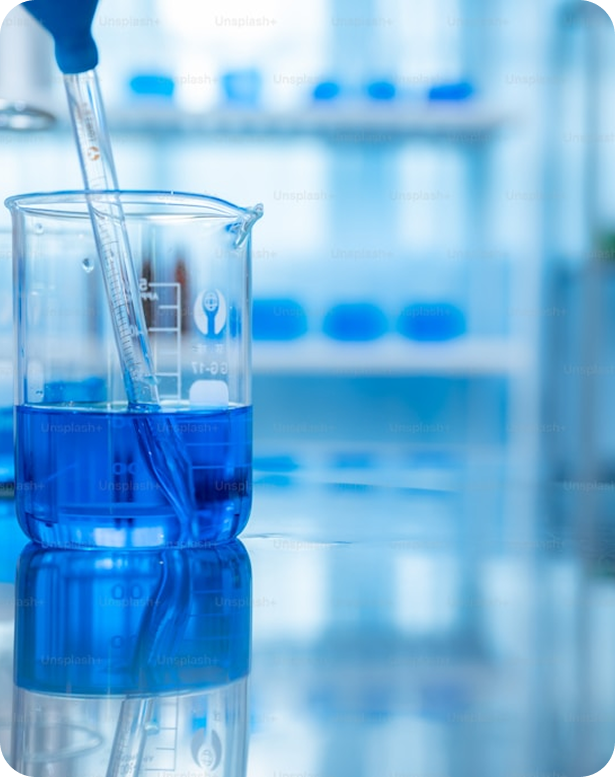 Pipeta vertiendo líquido azul en vaso de precipitados dentro de laboratorio