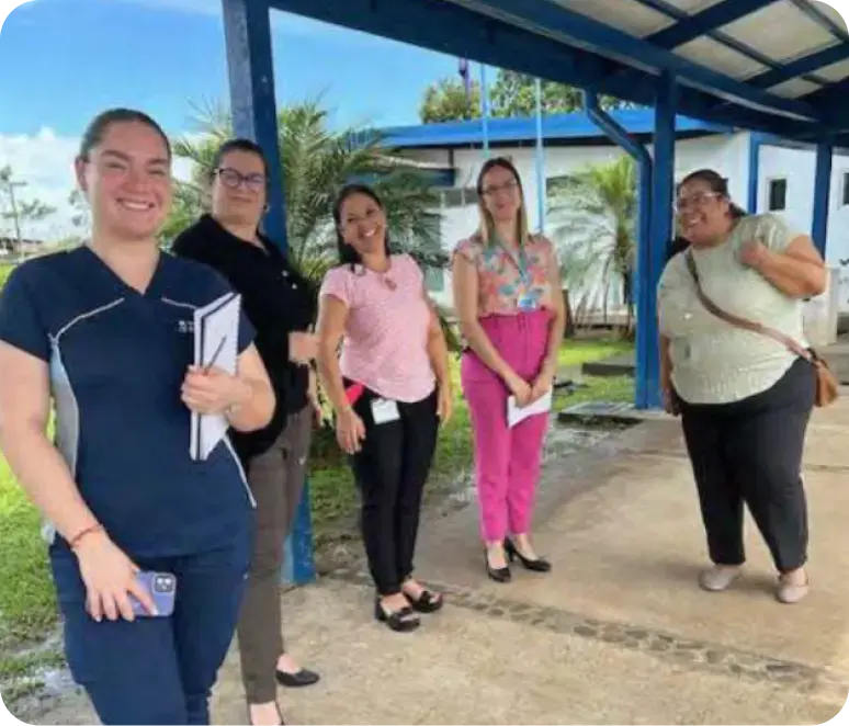 Grupo de colaboradoras de una institución sonriendo al aire libre.